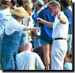 A dancing woman in overalls at the park.